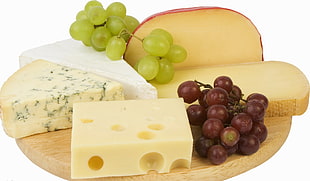 six typed of cheeses and two green and red grapes