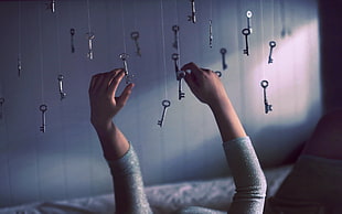 woman in gray holding gray skeleton keys HD wallpaper