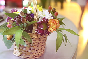 white, purple and orange flowers on wicker basket