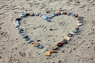 stones in heart-shape on brown sand