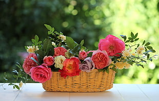 assorted flowers in brown wicker basket in tilt shift lens photography