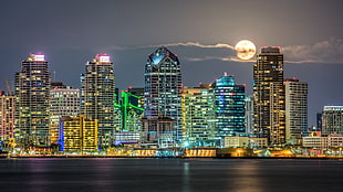 city light in buildingg under full-moon