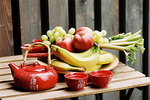 red ceramic teapot beside fruits