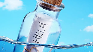 clear glass bottle with help letter