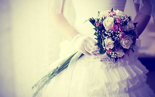 person holding wedding bouquet and wearing white ruffled dress