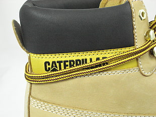 unpaired brown,black,and yellow Caterpillar brand work boots