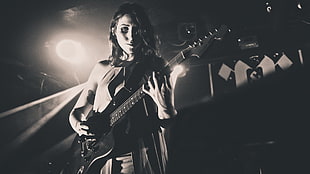 gray scale photo of woman playing electric guitar