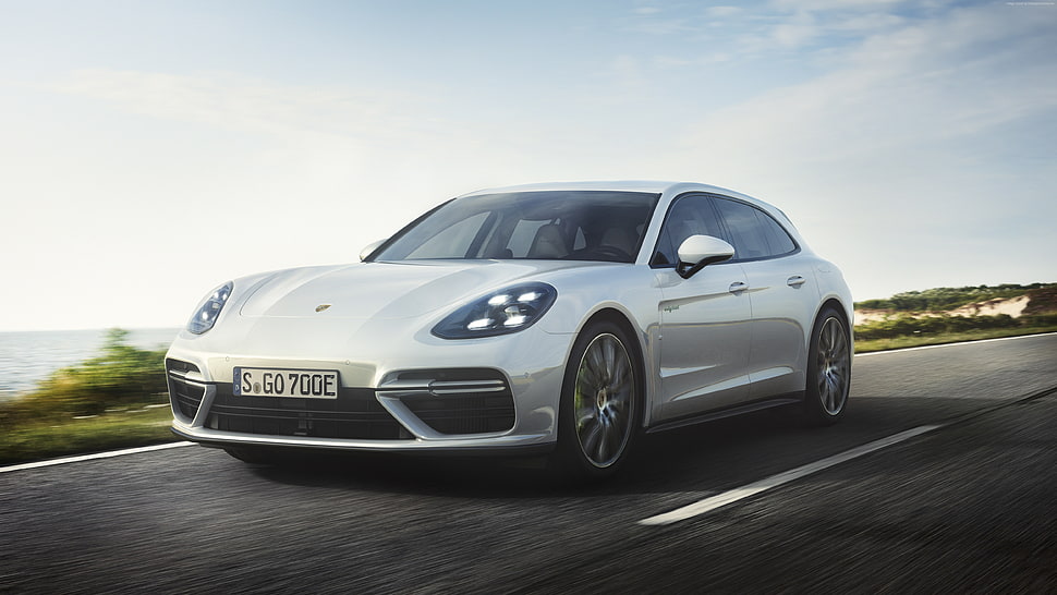 white Porsche Panamera running on road by the sea HD wallpaper