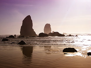 silhouette of rock formation and sea at daytime