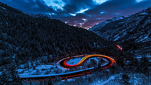 timelapse photography of moving cars on mountain road during nighttime HD wallpaper