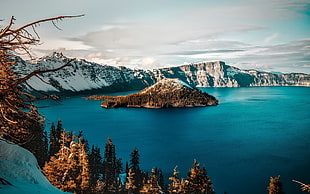 island in the middle of body of water and snow-covered mountains, crater lake, island