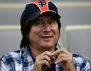 man wearing black and orange fit cap