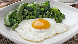 Sunny side up egg with peas on white ceramic palte