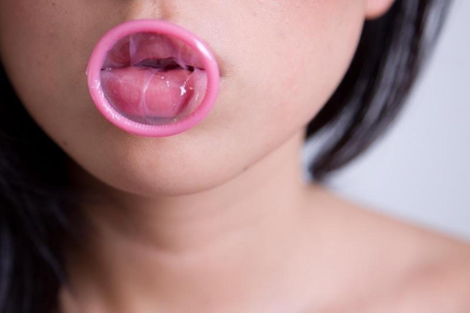 pink condom in person's mouth.