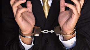 person wearing suit with handcuffs
