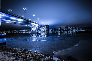 panoramic photography of lighted bridge and city buildings during night time