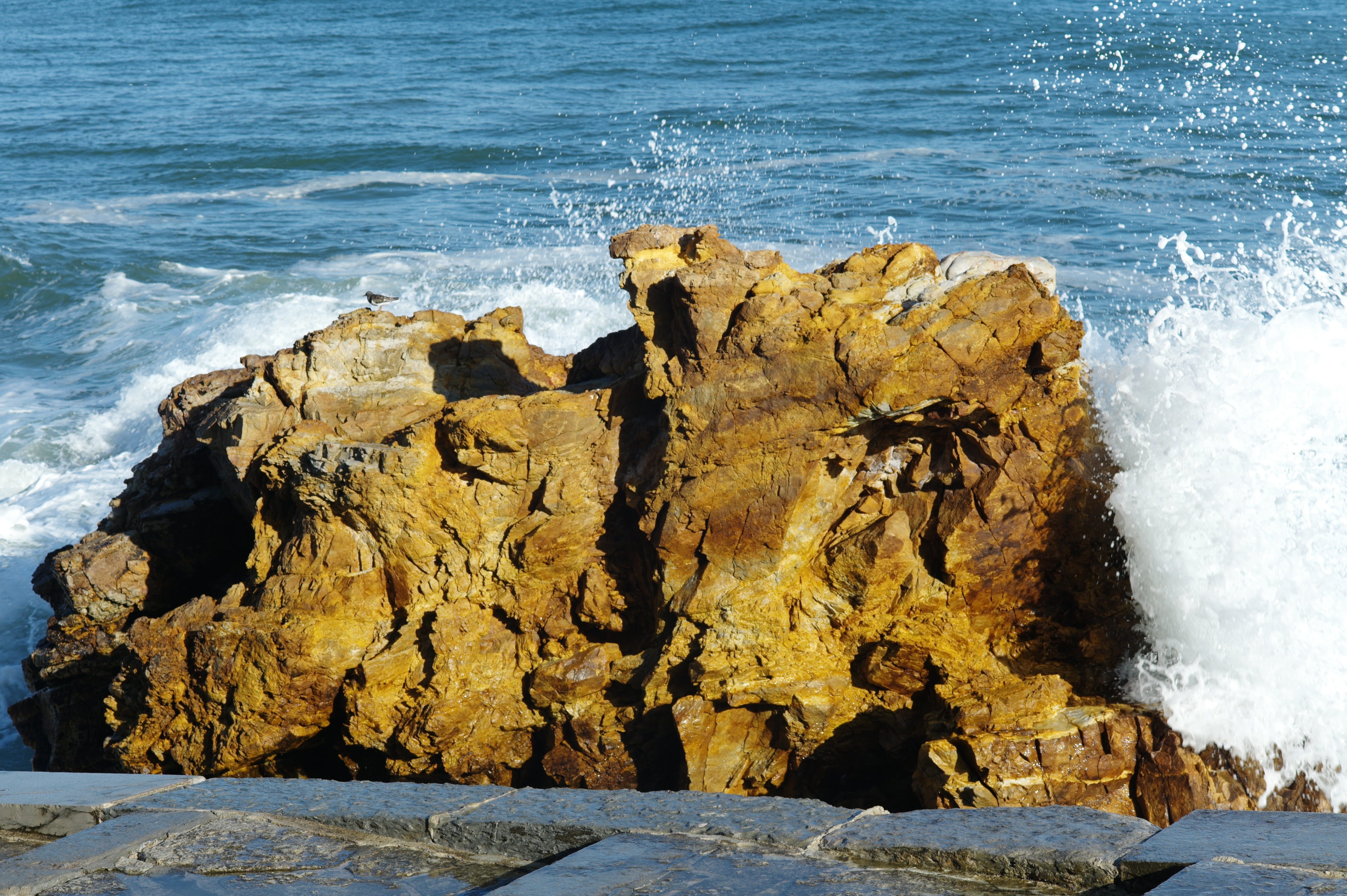 rock formation and sea waves during daytime