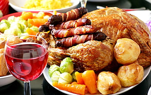 roasted chicken beside wine glass with red liquid