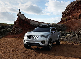 photography of gray Renault pickup truck on soil cliff