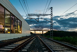 grey metal train railways beside concrete building