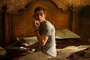 man in gray shirt holding telephone HD wallpaper