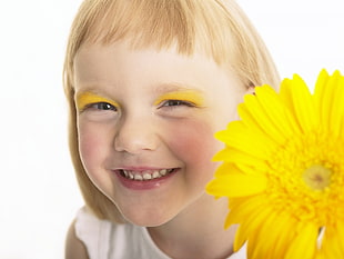 smiling girl holding yellow Gerbera flower