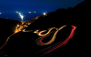time lapse photography of vehicle passing, road, long exposure, hairpin turns, light trails
