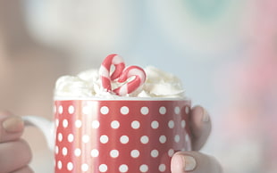 selective focus photography of red and white polka-dot ceramic cup