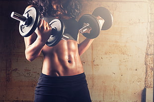 woman holding two adjustable dumbbells