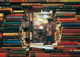 stacked of assorted-title book forming round hole in the middle HD wallpaper