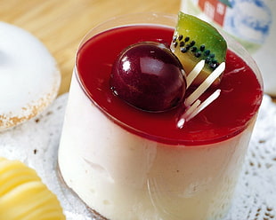 kiwi and cherry fruits on top of cup filled with white liquid substance