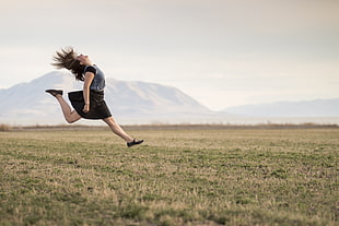 woman jumping on green grass