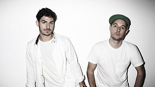 two men wearing white crewneck t-shirt leaning on the wall