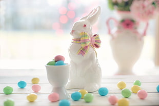 white ceramic rabbit figurine beside egg candies