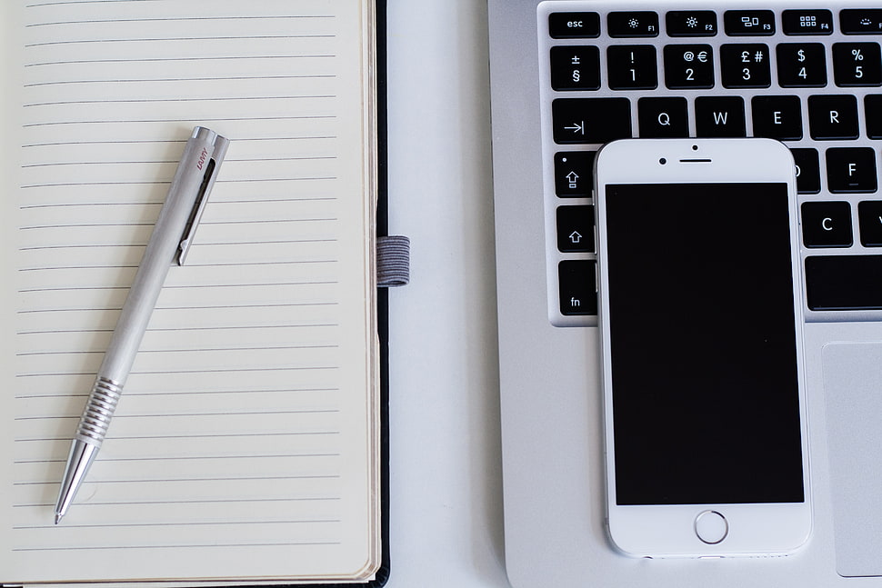 silver iPhone 6 on laptop computer and gray retractable pen on notebook HD wallpaper
