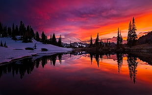 three beside calm body water across snow covered mountain during golden hour, lake, sunset, mountains, forest