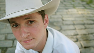 man wearing white cowboy hat with dress shirt at daytime