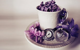 pocket watch beside flowers and cup with purple Lilac flower