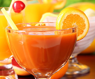 close-up photography of clear drinking glass filled with orange liquid HD wallpaper