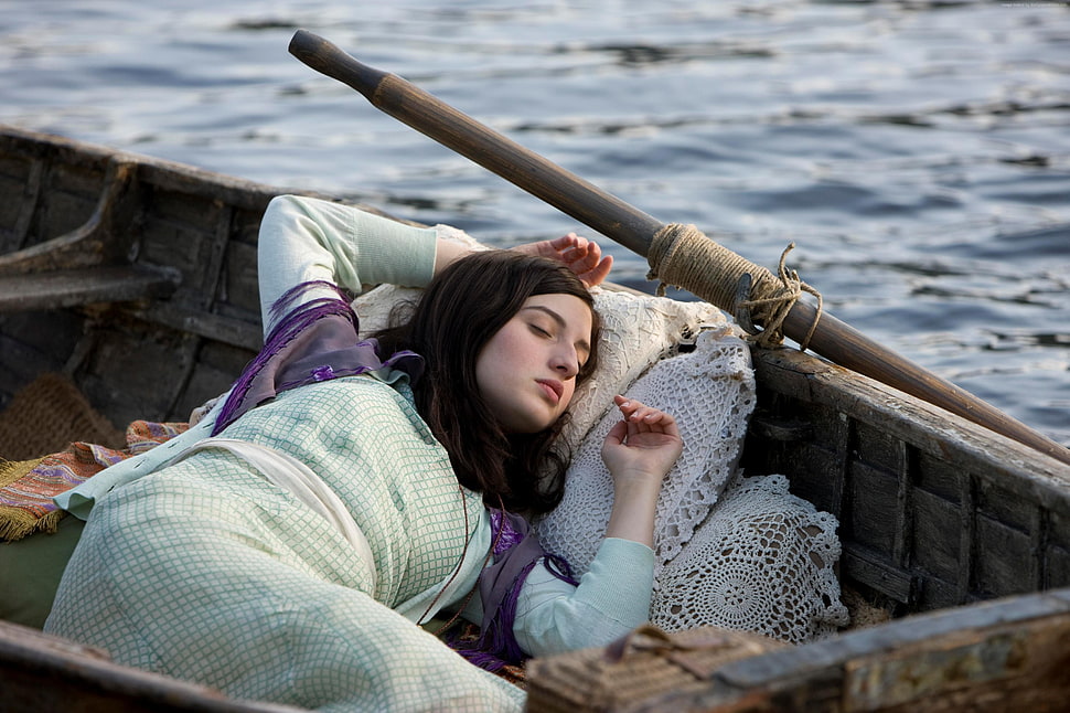 woman wearing teal dress sleeping on brown canoe on sea during daytime HD wallpaper