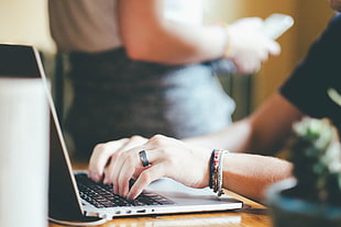 woman in black top typing on gray laptop computer
