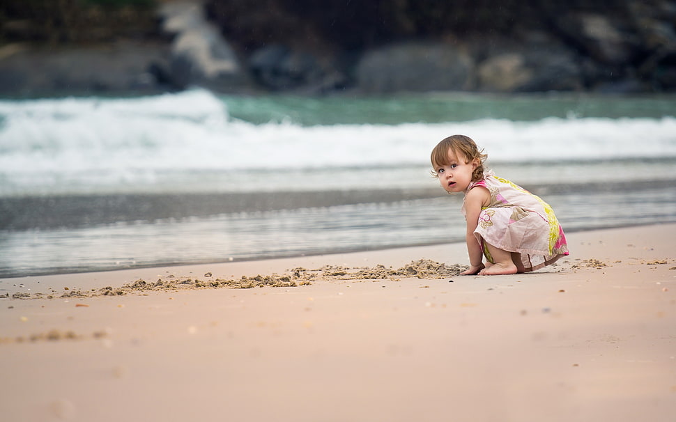 toddler wearing yellow and white dress on seashore HD wallpaper