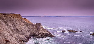 landscape photography of rock formation beside seashore