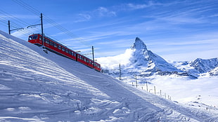 red train and white mountains at daytime