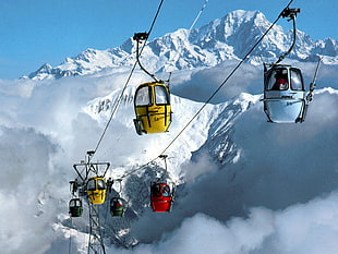 assorted-color cable cars, mountains, snow, ski lifts, clouds
