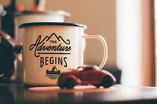 white ceramic mug with The Adventure Begins print HD wallpaper