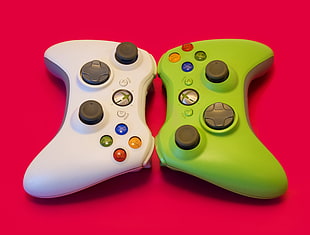 white and green Xbox 360 game controllers