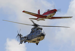 red plane above black helicopter on flight