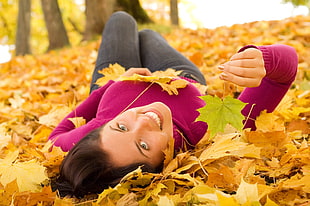 woman laying on bed of maple leaf