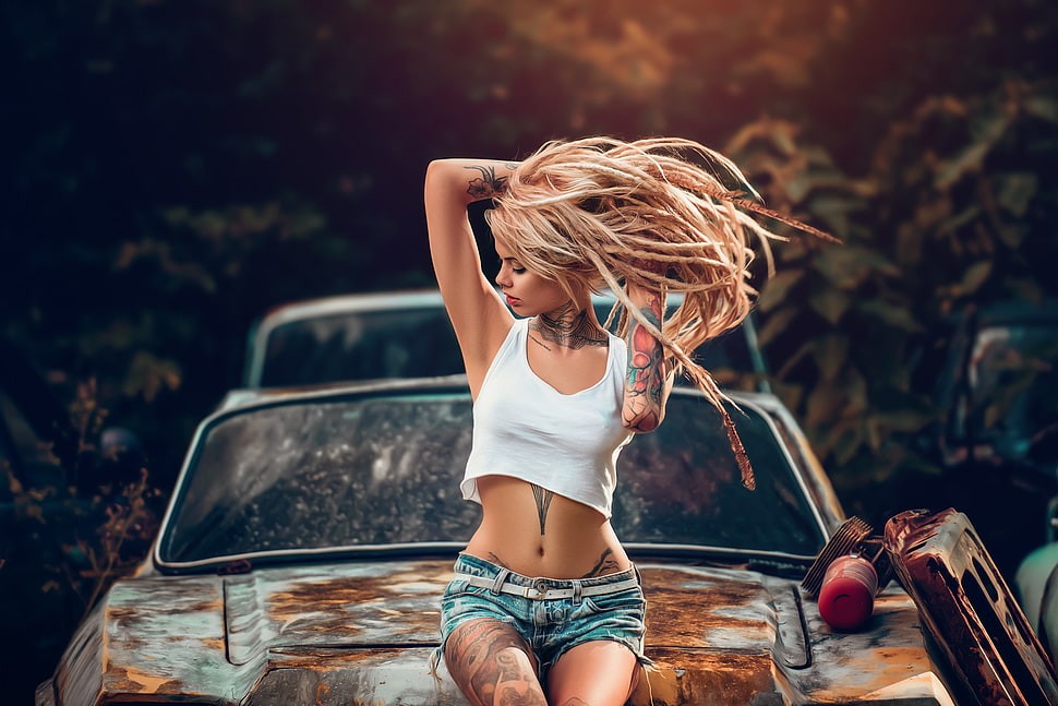 woman wearing white crop top and blue shorts sitting on hood of car HD wallpaper